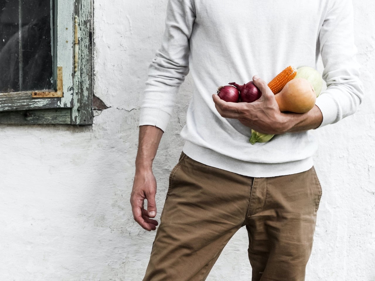 Hombre con vegetales, que son alimentos para bajar la tensión.
