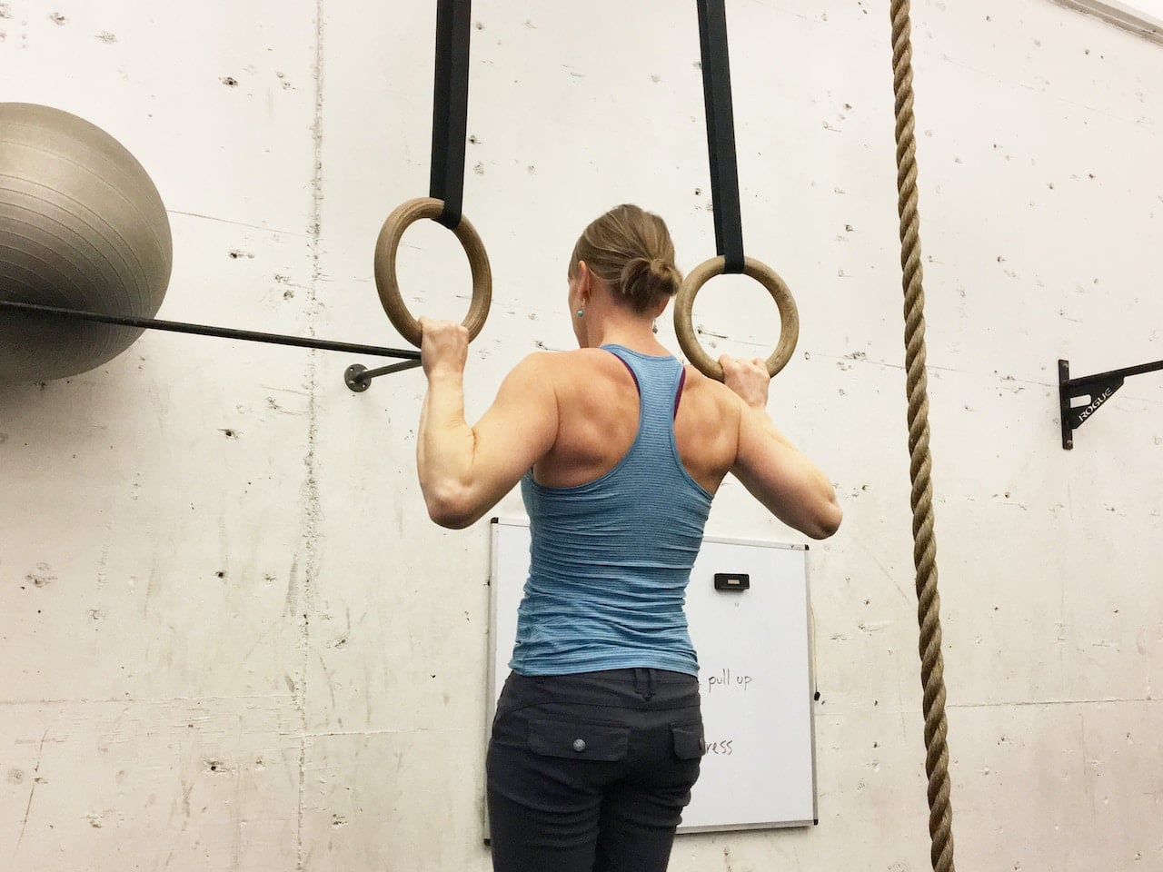 Mujer entrena en gimnasio y piensa en la nutrición en deportes de fuerza.