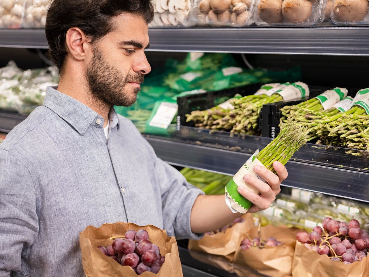 Hombre busca en un supermercado alimentos vegetales para una dieta vegetariana