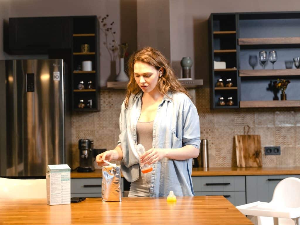 Mujer preparando la leche para el bebé en un biberón