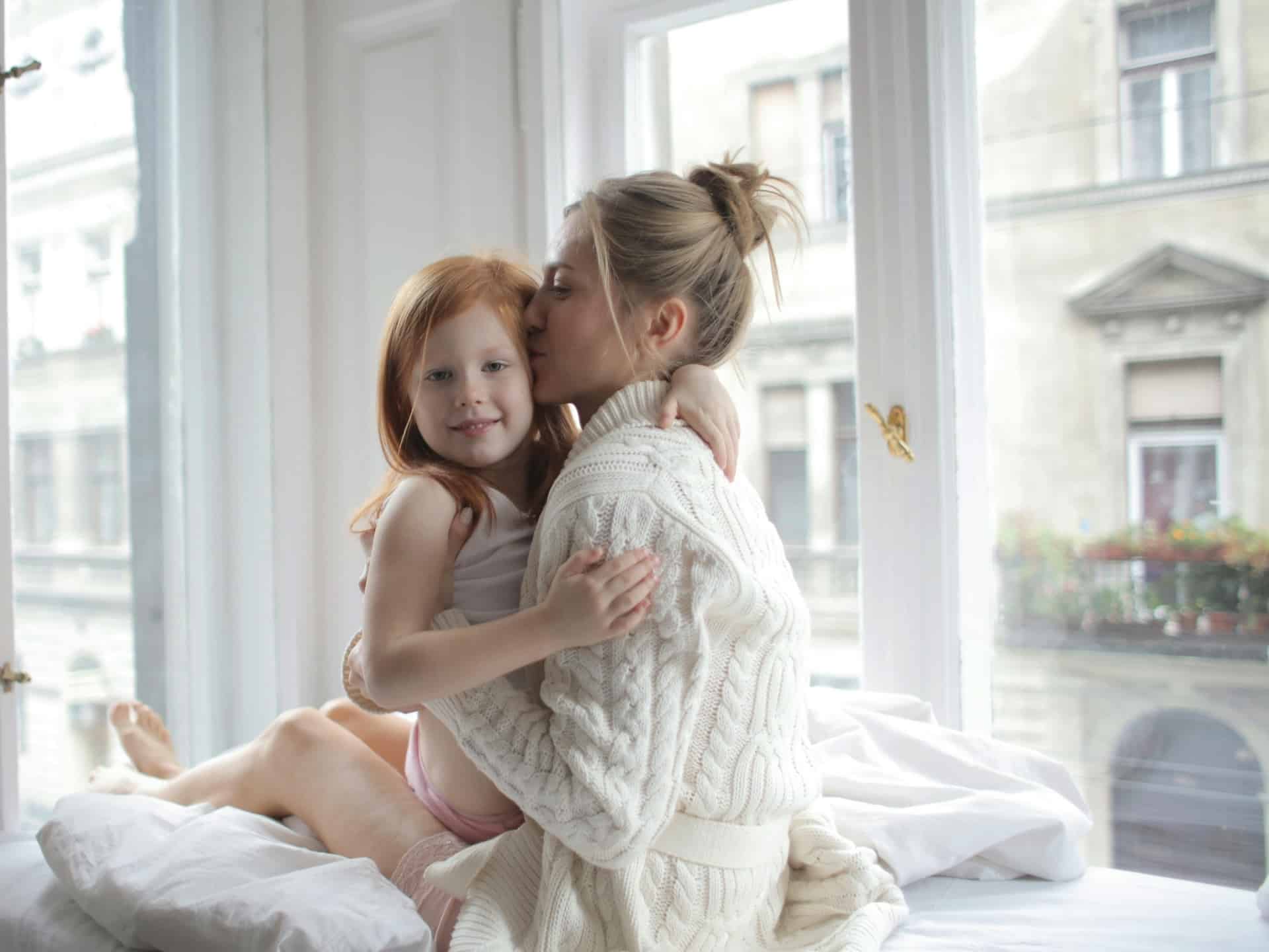 Mujer abraza a niña