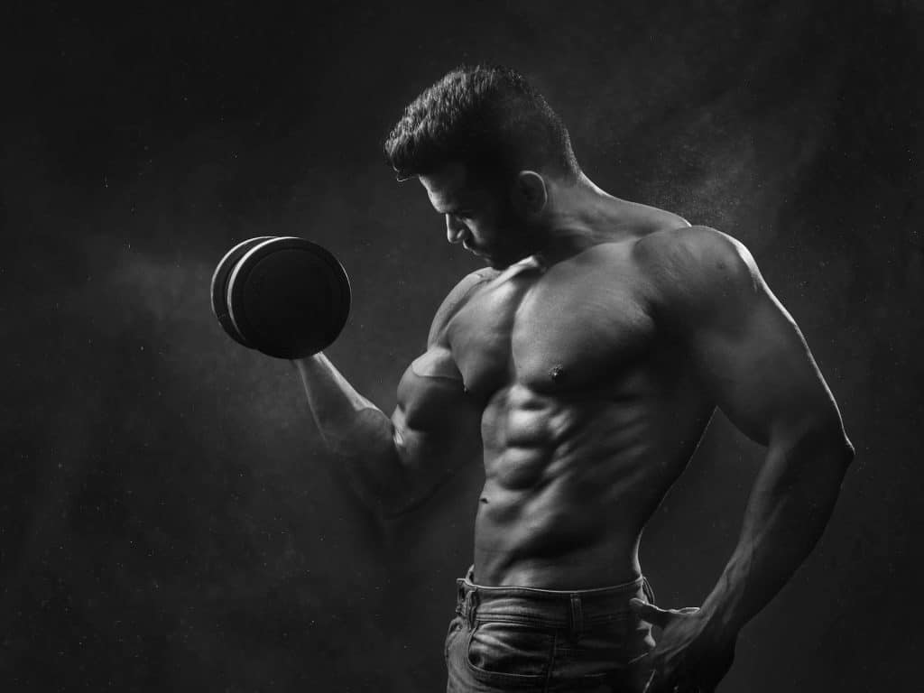 Hombre con mancuernas para aumentar masa muscular